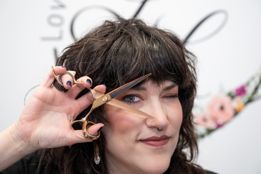 NJ Brand Photographer Lindsay Tiwald photographed Laura Lovely Locks. Laura looks through her scissors in this lifestyle photo.